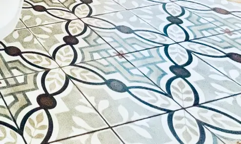 Decorative floor tiles with intricate black and beige geometric patterns forming interlocking shapes.