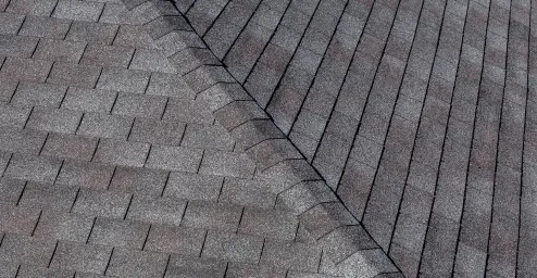 Gray asphalt shingle roof with overlapping rows forming a geometric pattern.